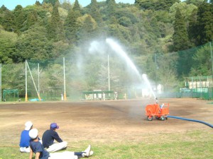 グラウンドに散水するスプリンクラー